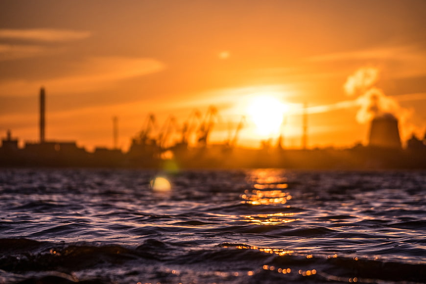 Blurred Industrial Port Silhouette at Golden Sunset Over Water
