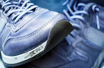Close-up of blue leather sneakers with textured rubber toe cap