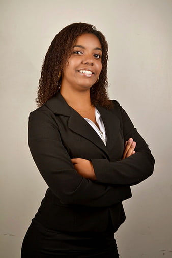 Confident young businesswoman in black blazer with arms crossed