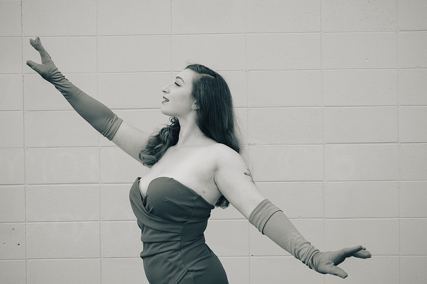 Vintage style woman in strapless dress and gloves posing