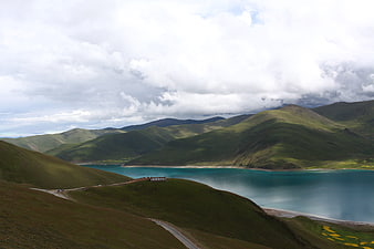 Scenic turquoise lake surrounded by green mountains in Tibet
