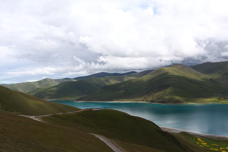 Scenic turquoise lake surrounded by green mountains in Tibet