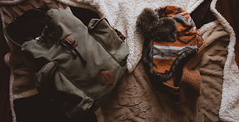 Cozy winter travel gear flat lay with backpack and hat