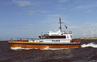 Orange and white pilot boat Lacerta on water with wind turbines
