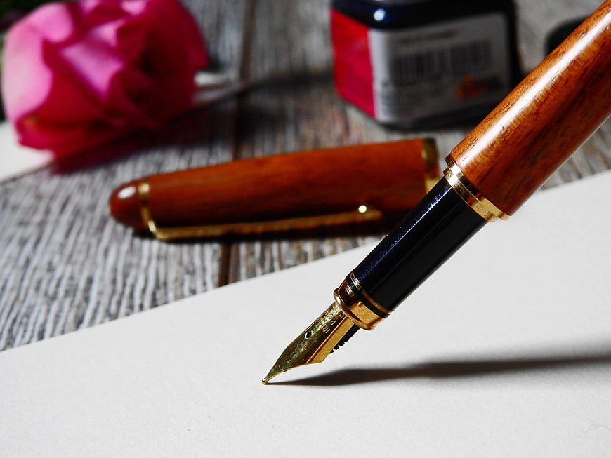 Close-up of wooden fountain pen on white paper
