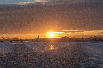 Sunset over frozen river in St. Petersburg with city skyline