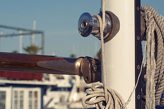 Close-up of sailboat winch, rope, and mast hardware