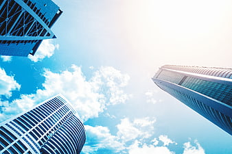 Low angle view of modern skyscrapers against blue sky