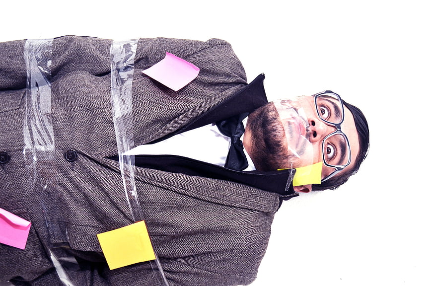Man in Suit Taped to Surface with Sticky Notes