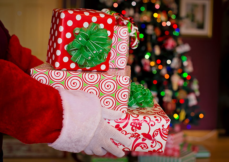 Santa Claus Holding Wrapped Christmas Gifts Near Tree