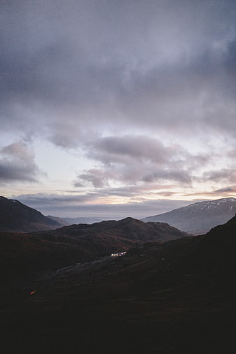 Dramatic moody mountain landscape at dusk with clouds