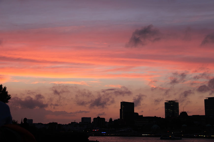 Vibrant pink and orange sunset over Hamburg city skyline silhouette