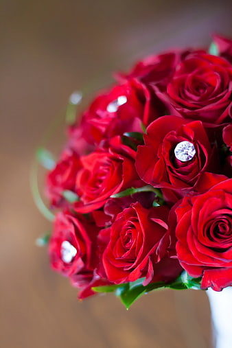 Close-up of red rose bridal bouquet with diamond ring