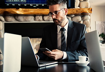 Businessman in Suit Using Smartphone at Desk