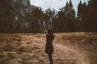 Woman in Black Coat Standing in Autumn Meadow