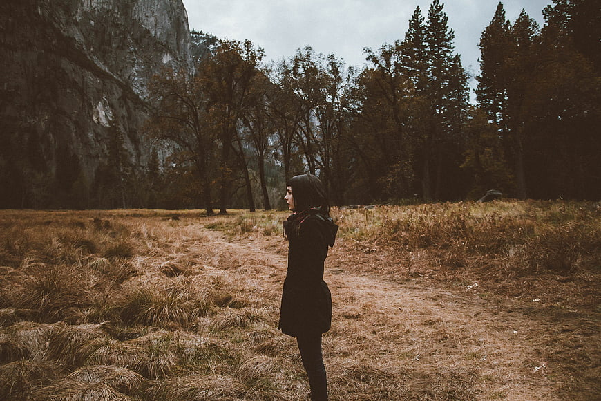 Woman in Black Coat Standing in Autumn Meadow