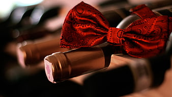 Red Wine Bottle With Red Patterned Bow Tie In Cellar