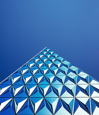 Modern Blue Geometric Glass Building Facade Against Clear Sky