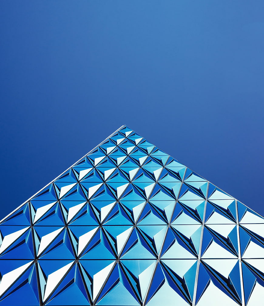 Modern Blue Geometric Glass Building Facade Against Clear Sky