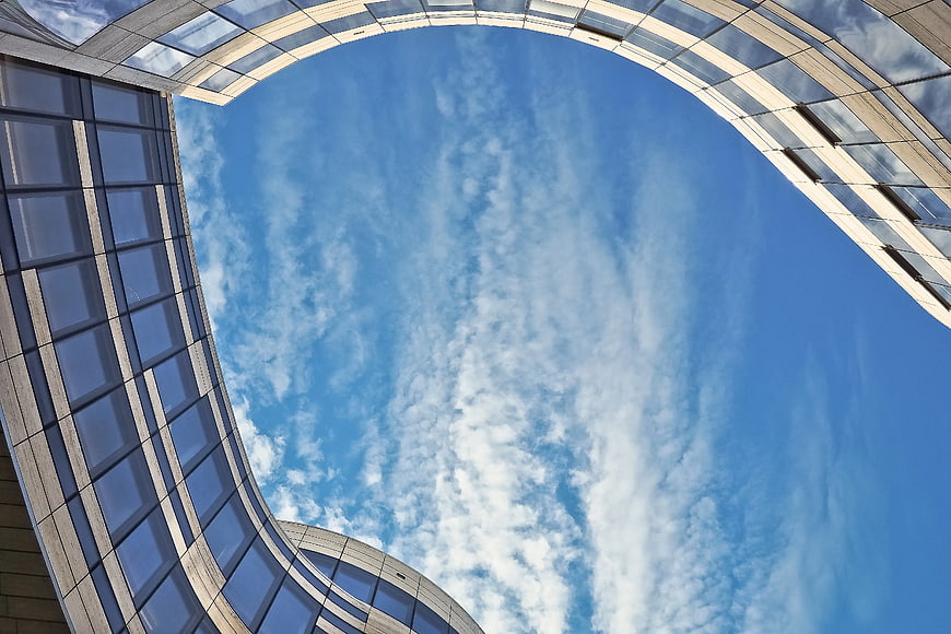Modern curved glass architecture against blue sky