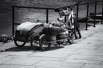 Loaded touring bicycle with trailer parked by waterfront