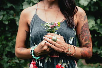 Tattooed Woman Holding Wildflowers in Garden