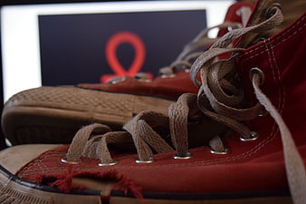 Close-up of worn red canvas sneakers with untied laces