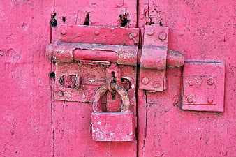 Rusty Red Padlock on Weathered Wooden Door