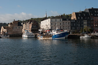 Fishing boats docked in Honfleur harbor with historic buildings
