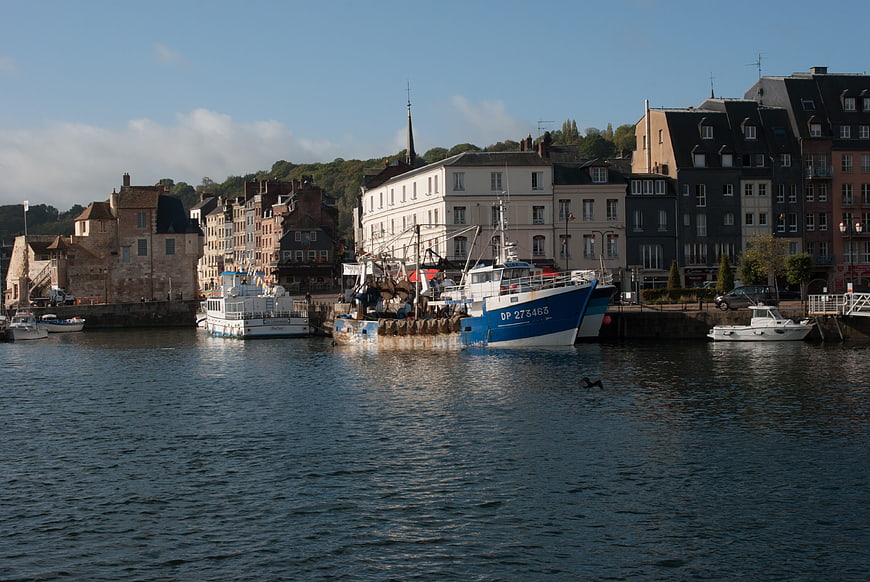 Fishing boats docked in Honfleur harbor with historic buildings