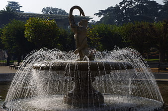 Ornate fountain with lion sculpture spraying water in park
