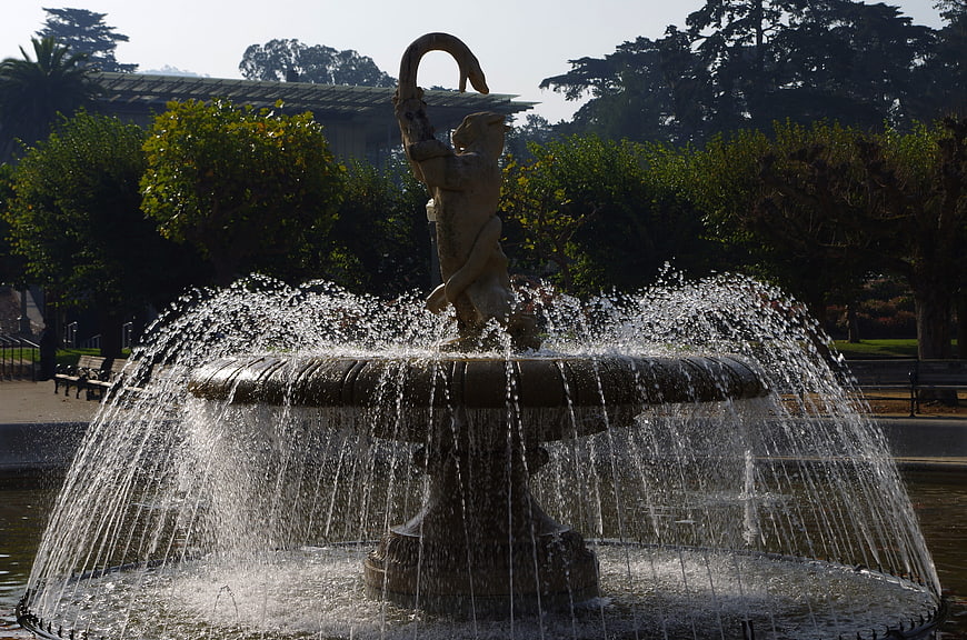 Ornate fountain with lion sculpture spraying water in park