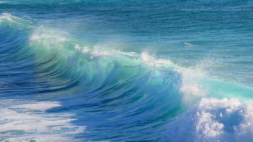Turquoise ocean wave crashing with white sea foam