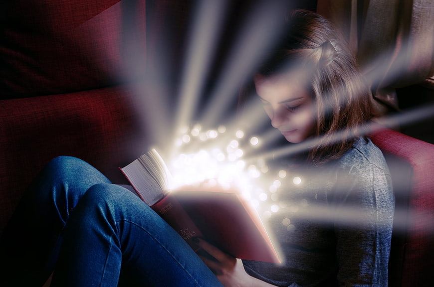 Girl Reading Magical Glowing Book on Sofa
