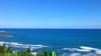 Coastal Ocean View With Blue Sky And Green Foliage