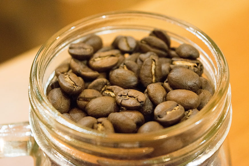 Close-up of roasted coffee beans in a glass jar