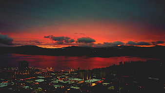 Dramatic Red Sunset Over Coastal City and Mountains