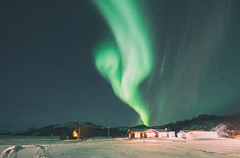 Vibrant Green Aurora Borealis Over Snowy House at Night