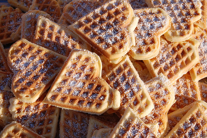 Heart-shaped waffles with powdered sugar close-up