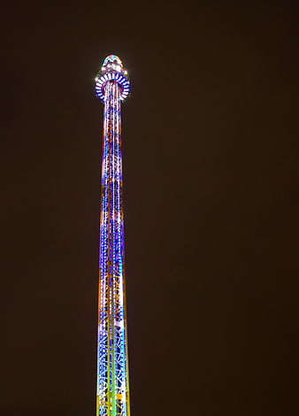 Illuminated Drop Tower at Night with Neon Lights