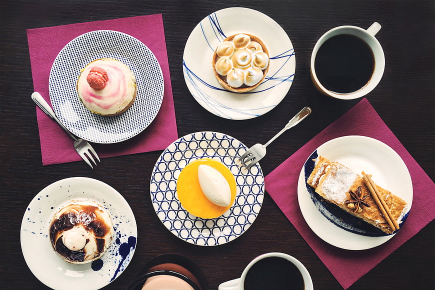 Overhead View of Assorted Desserts and Coffee on Dark Table