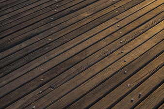 Diagonal wooden deck planks with metal screws texture background