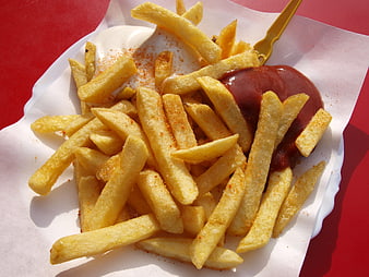 Golden french fries with ketchup and mayonnaise on red background