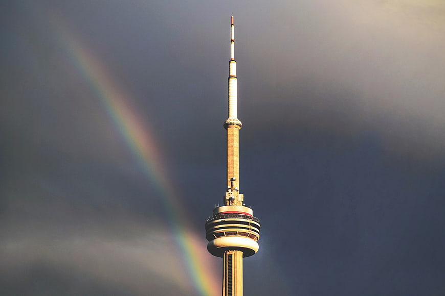 CN Tower with Rainbow Against Dramatic Cloudy Sky