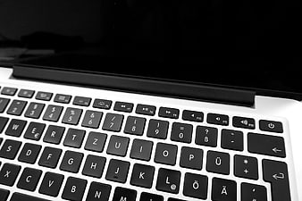 Close-up of laptop keyboard with black keys and white chassis