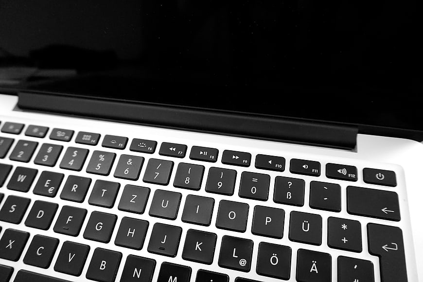 Close-up of laptop keyboard with black keys and white chassis