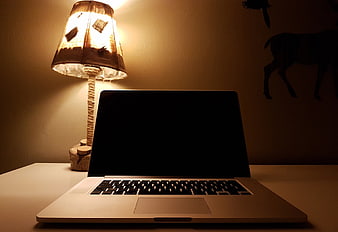 Laptop on Desk with Warm Lamp Light at Night