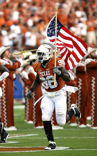 Texas football player running with American flag on field