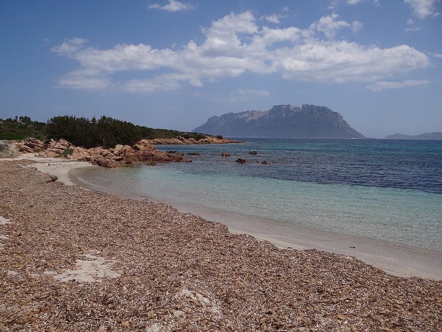 Secluded pebble beach with turquoise water and distant mountain