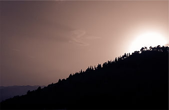 Silhouette of Mountain Ridge Against Hazy Sunset Sky